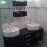 WALL MOUNT VANITY WITH DUAL SINKS, MIRRORS AND VANITY LIGHTS. MARBLE TILE ALL THE WAY AROUND MAIN WALLS TO CEILING